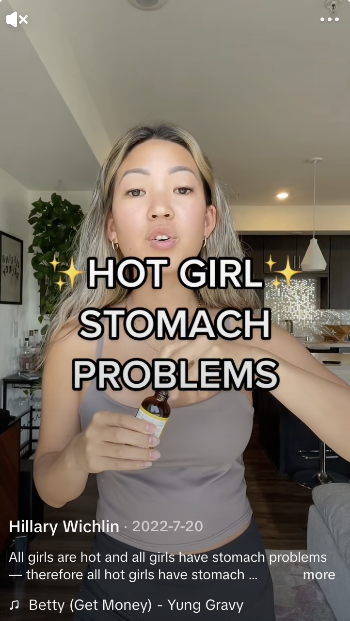 A woman holds up a dropper bottle of product behind the caption text, "Hot girl stomach problems."